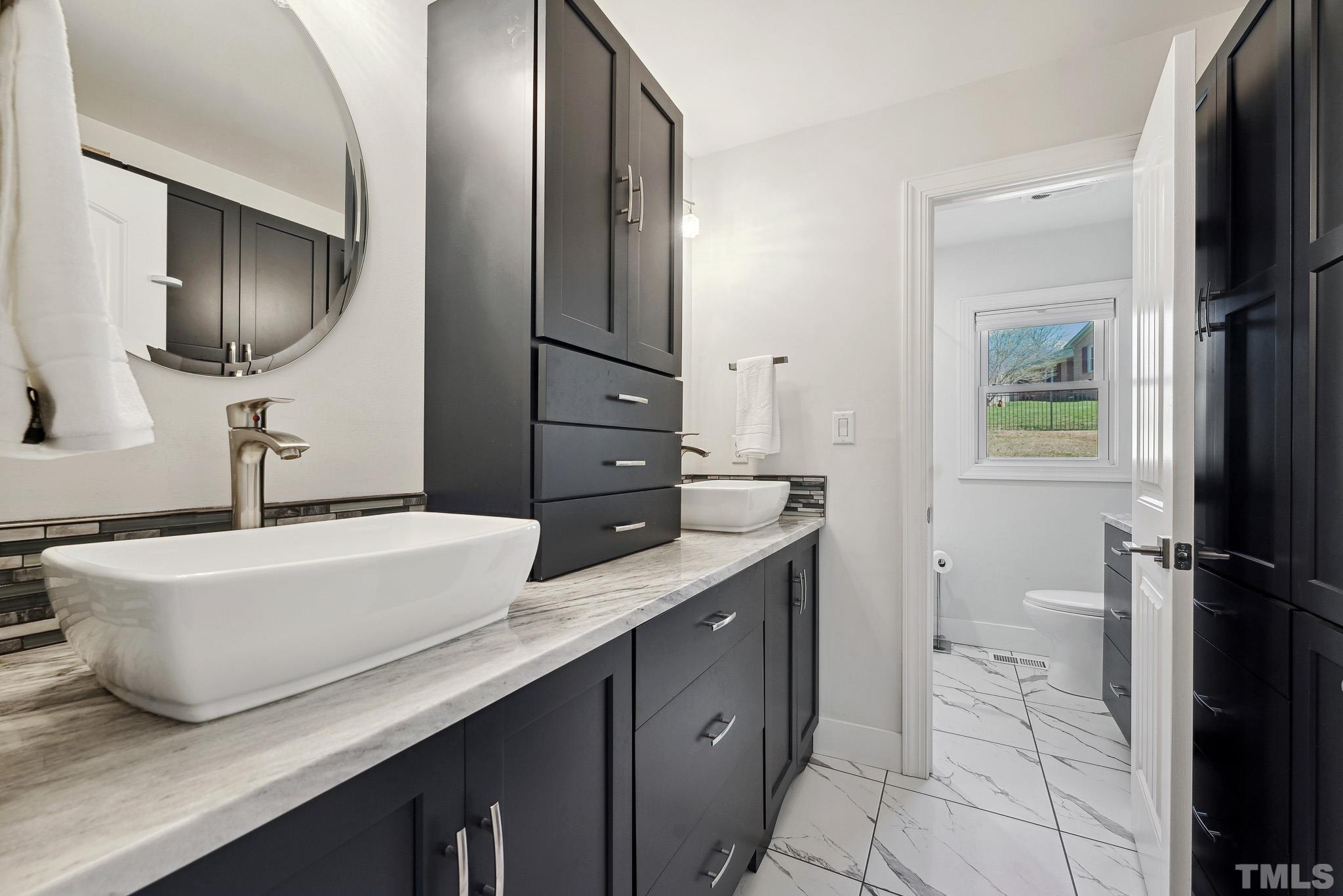 2632 Purnell Road Wake Forest, NC 27587 - Photo 19 of 60 a spacious bathroom with a granite countertop sink a mirror and a toilet
