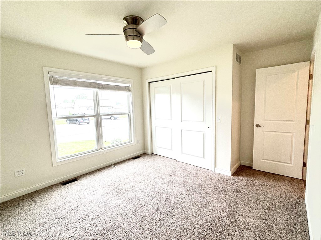 1132 Hummingbird Way Findlay, OH 45840 - Photo 10 of 28 Unfurnished bedroom with carpet, a closet, and a ceiling fan