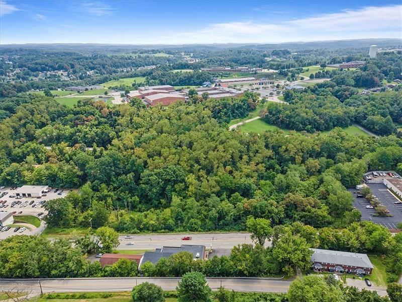 an aerial view of residential houses with outdoor space and trees