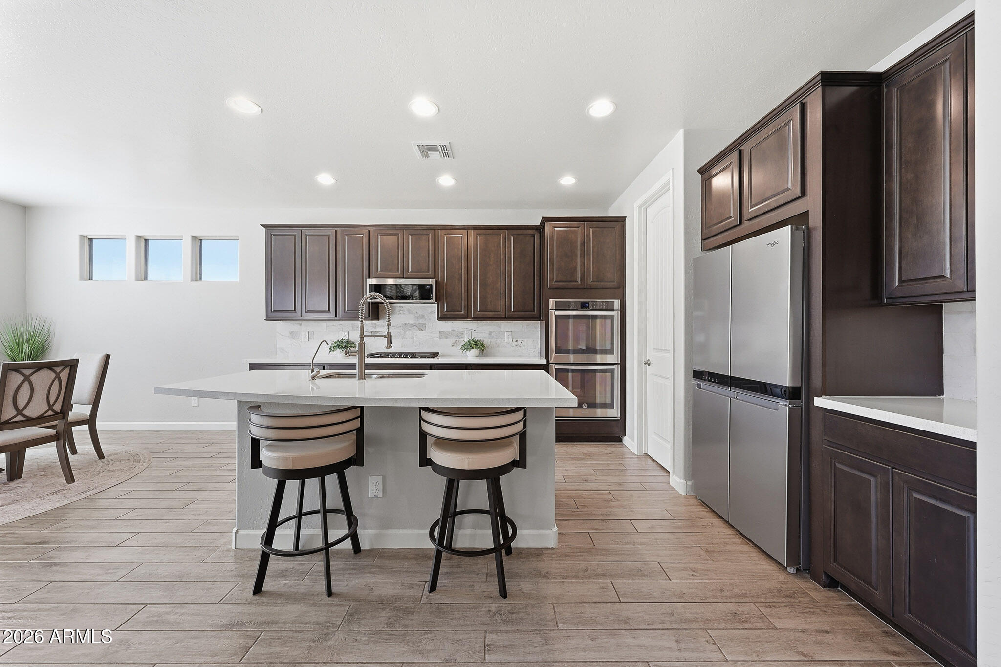 22133 East Russet Road Queen Creek, AZ 85142 - Photo 22 of 61 a kitchen with kitchen island granite countertop wooden cabinets and stainless steel appliances