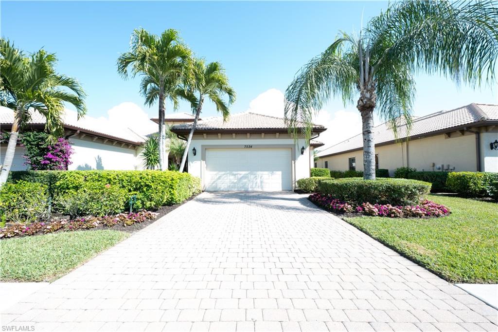 7524 Moorgate Point Way Naples, FL 34113 - Photo 1 of 1 View of front facade with decorative driveway, stucco siding, a tile roof, a garage, and a front lawn