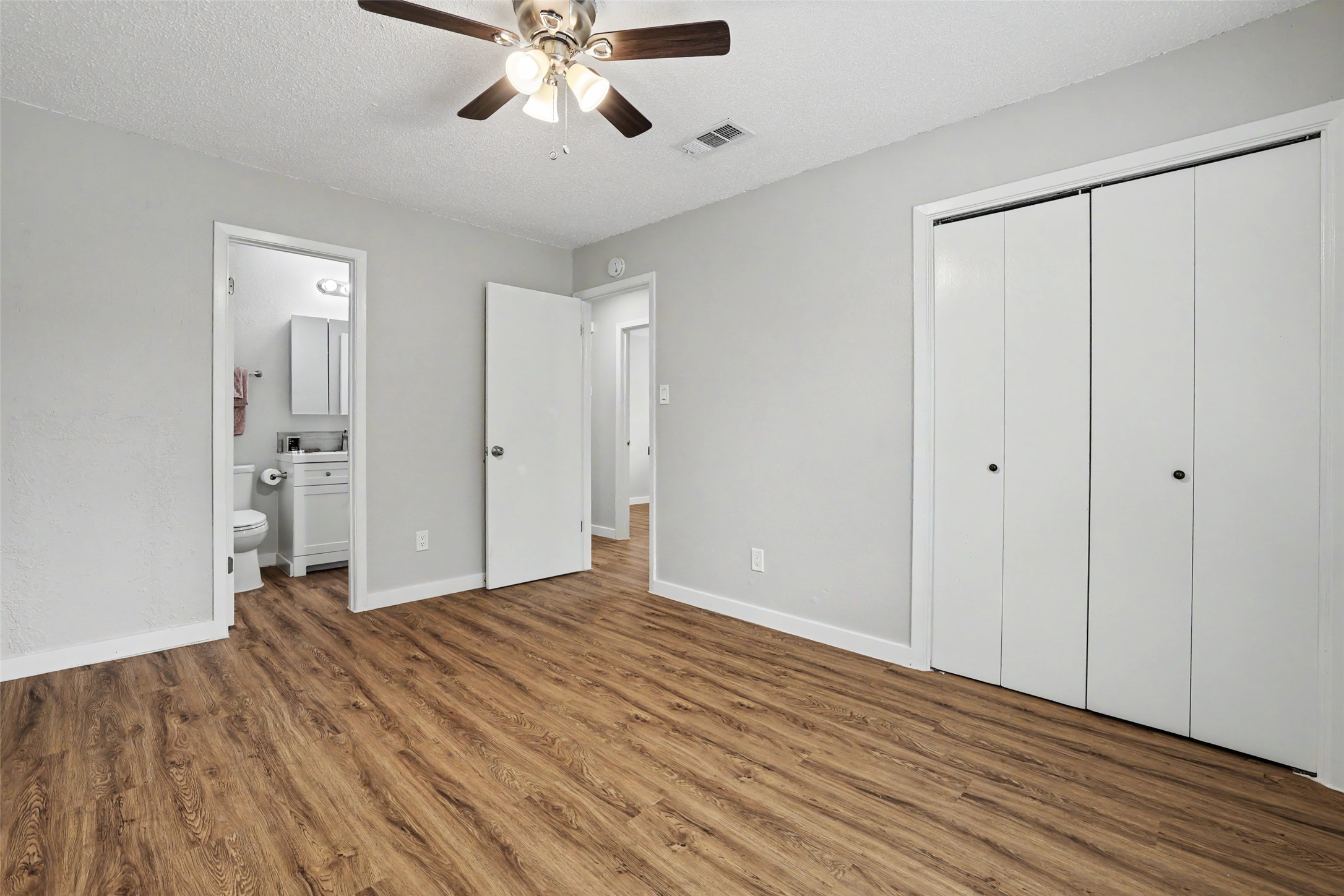 802 Ranch Road, Unit A Georgetown, TX 78628 - Photo 10 of 21 A well-lit bedroom features durable wood-look flooring and convenient access to an adjacent bathroom.