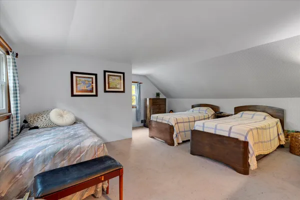 a bedroom with two beds and painting on the wall
