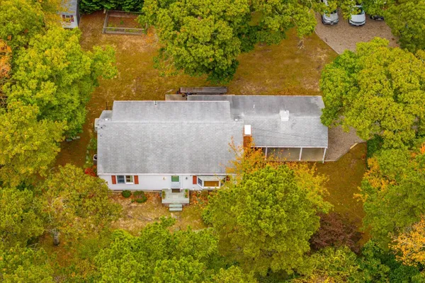 an aerial view of residential house with swimming pool and large trees
