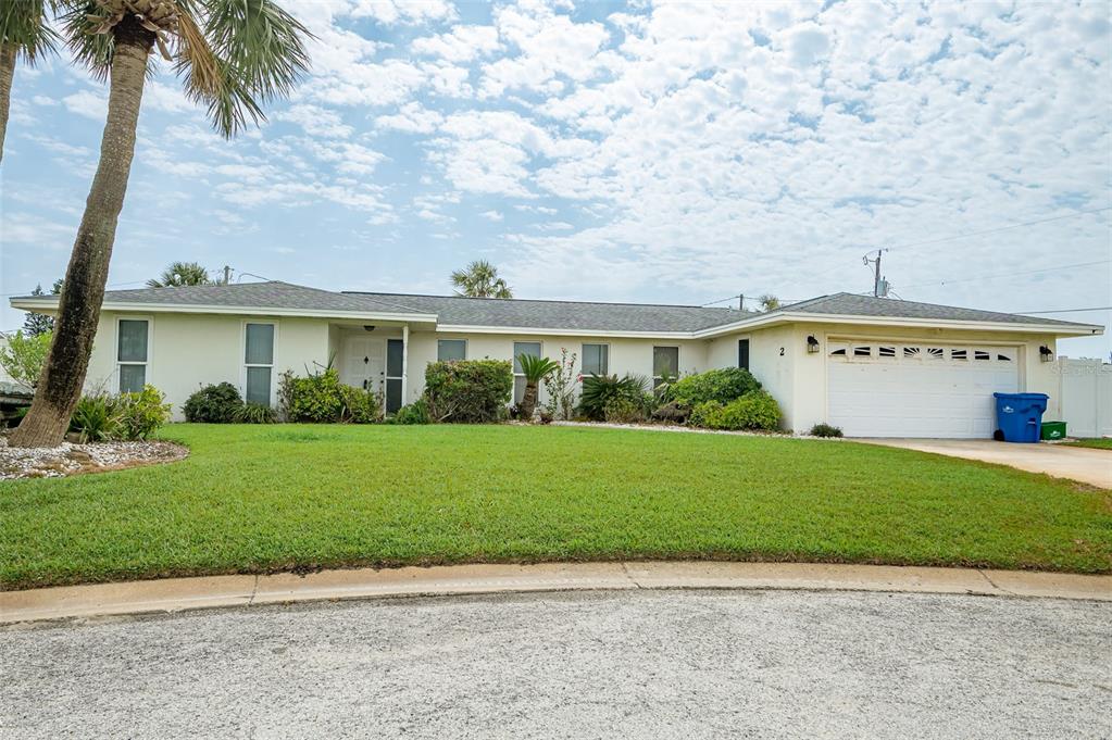 a view of a big house with a big yard and palm trees