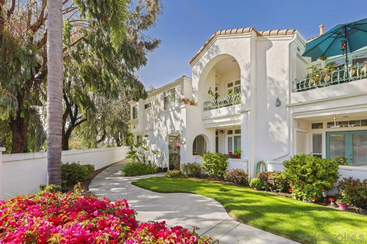 a view of a white house with a big yard and potted plants