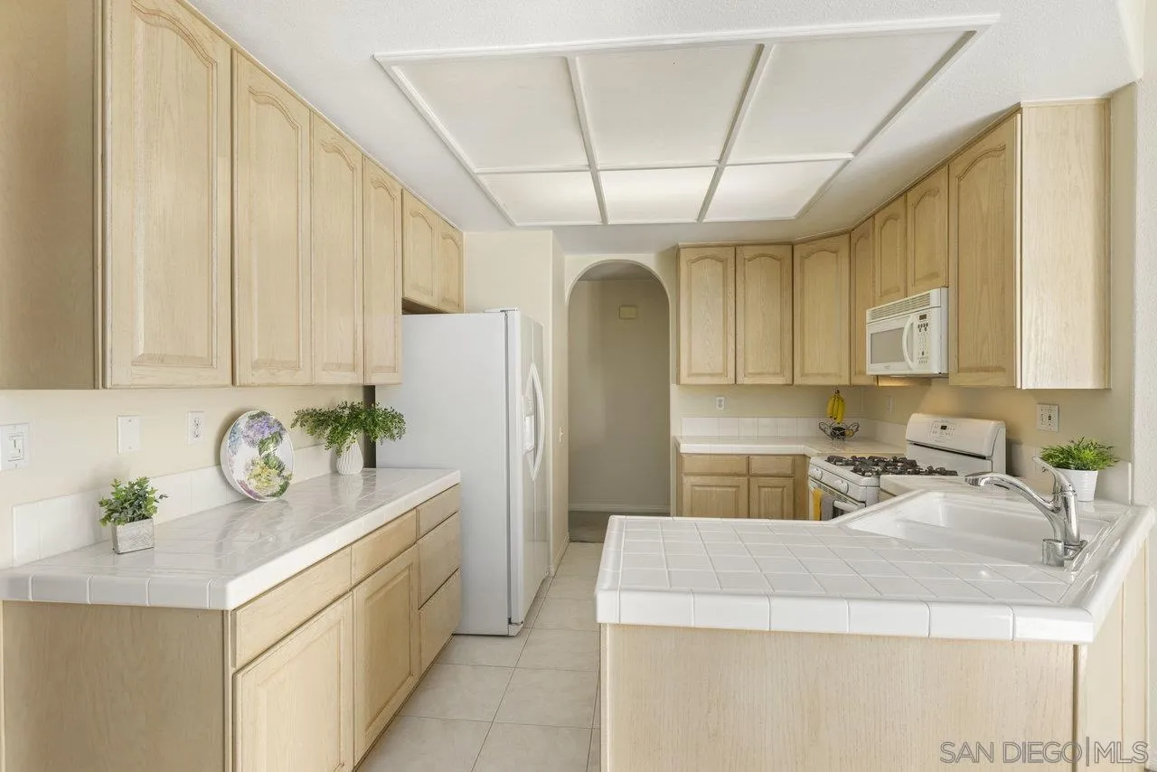 3365 Genoa Way, Unit 140 Oceanside, CA 92056 - Photo 11 of 32 a kitchen with stainless steel appliances granite countertop a sink window and cabinets