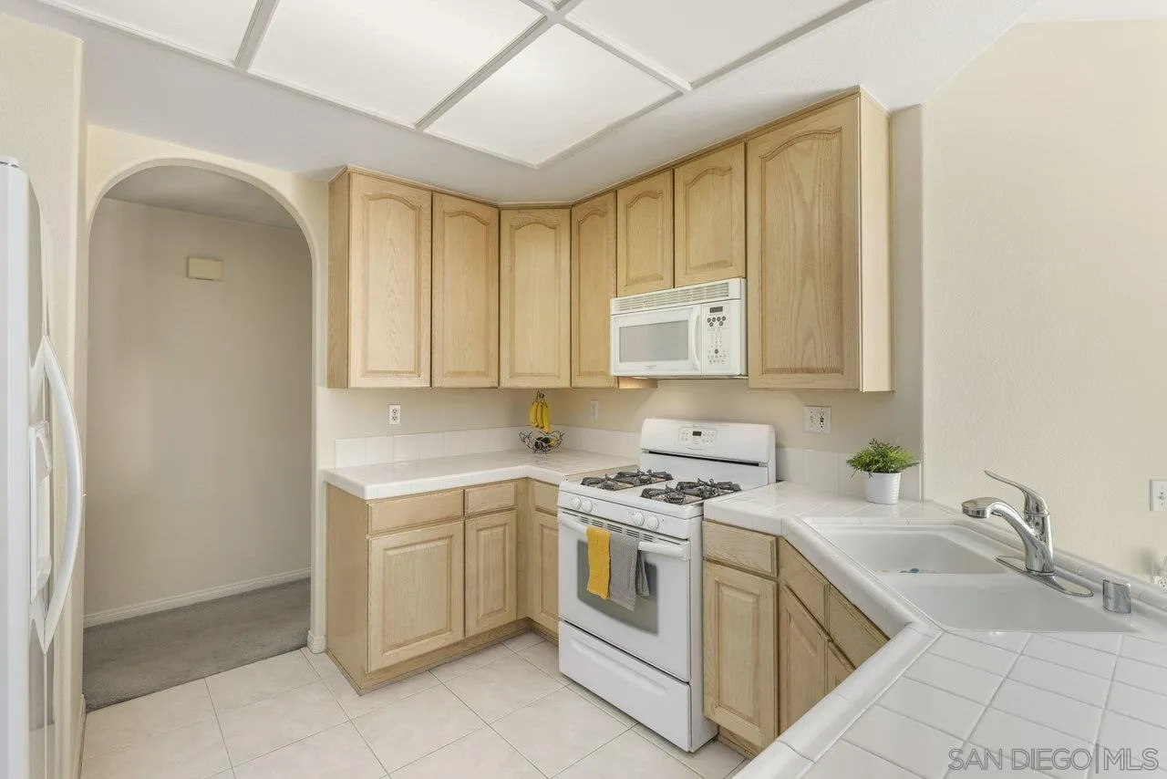 3365 Genoa Way, Unit 140 Oceanside, CA 92056 - Photo 12 of 32 a kitchen with cabinets appliances and a window