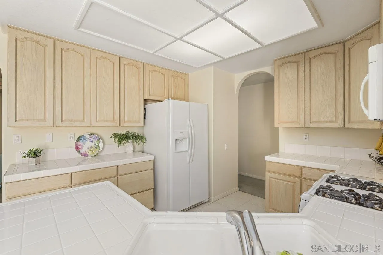 3365 Genoa Way, Unit 140 Oceanside, CA 92056 - Photo 13 of 32 a kitchen with stainless steel appliances granite countertop a refrigerator a stove a sink and dishwasher with a dishwasher