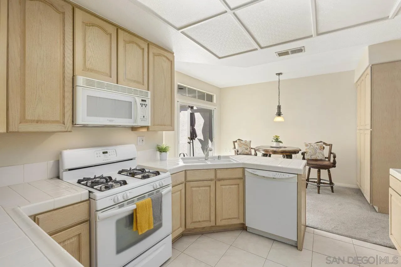 3365 Genoa Way, Unit 140 Oceanside, CA 92056 - Photo 14 of 32 a kitchen with sink a stove and cabinets