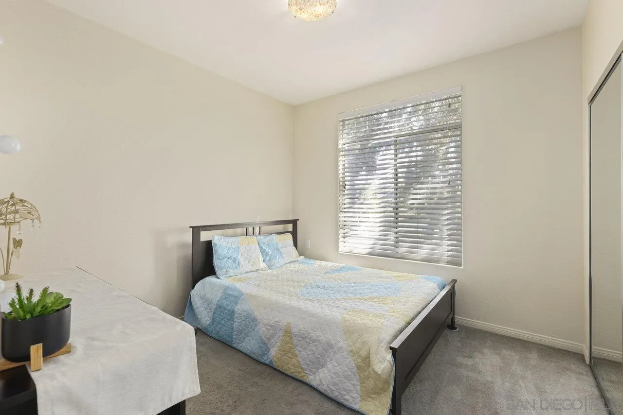 3365 Genoa Way, Unit 140 Oceanside, CA 92056 - Photo 19 of 32 a bedroom with a bed and a window