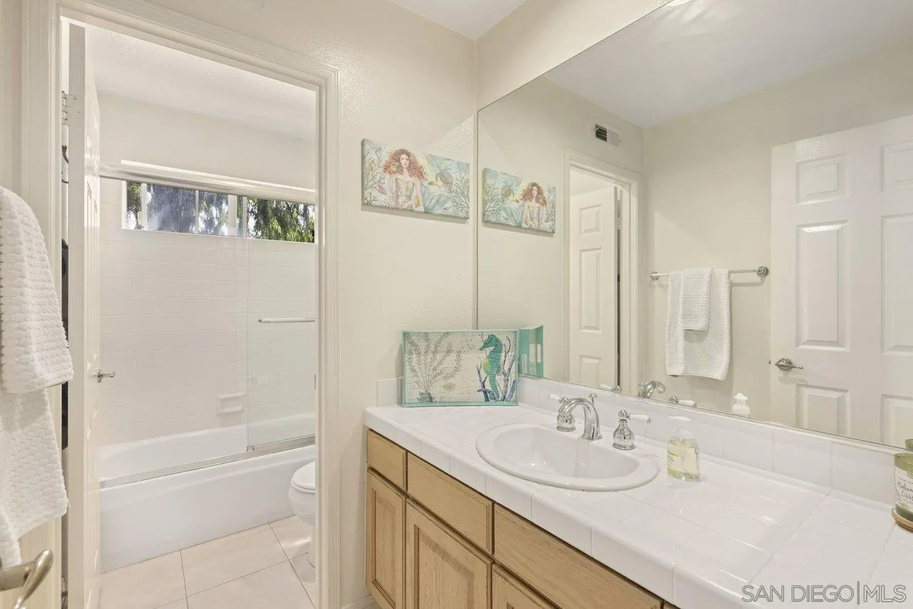 3365 Genoa Way, Unit 140 Oceanside, CA 92056 - Photo 21 of 32 a bathroom with a granite countertop sink a toilet and shower