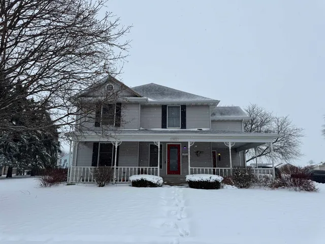a front view of a house with a yard covered in snow
