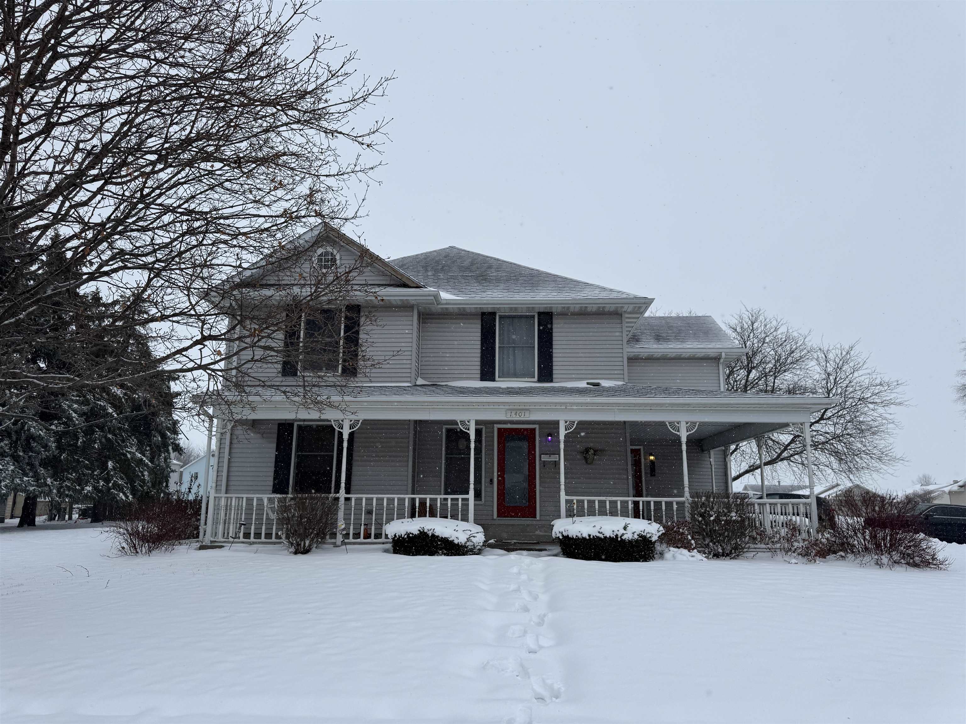 a front view of a house with a yard covered in snow