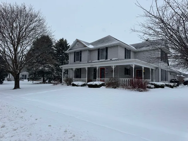 a view of a house with a yard covered in snow