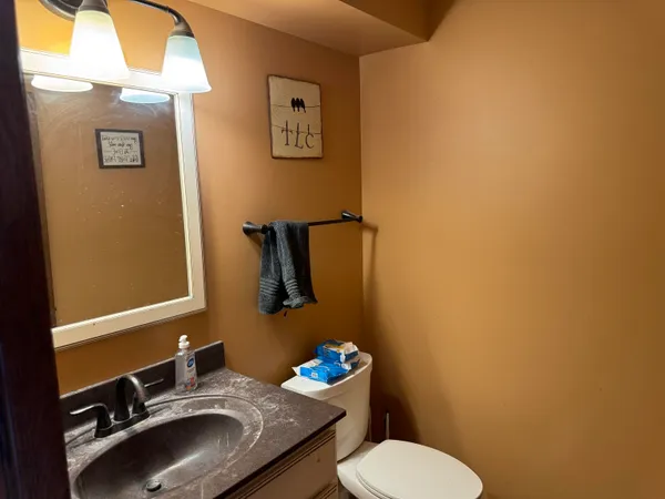 a bathroom with a sink mirror vanity and toilet