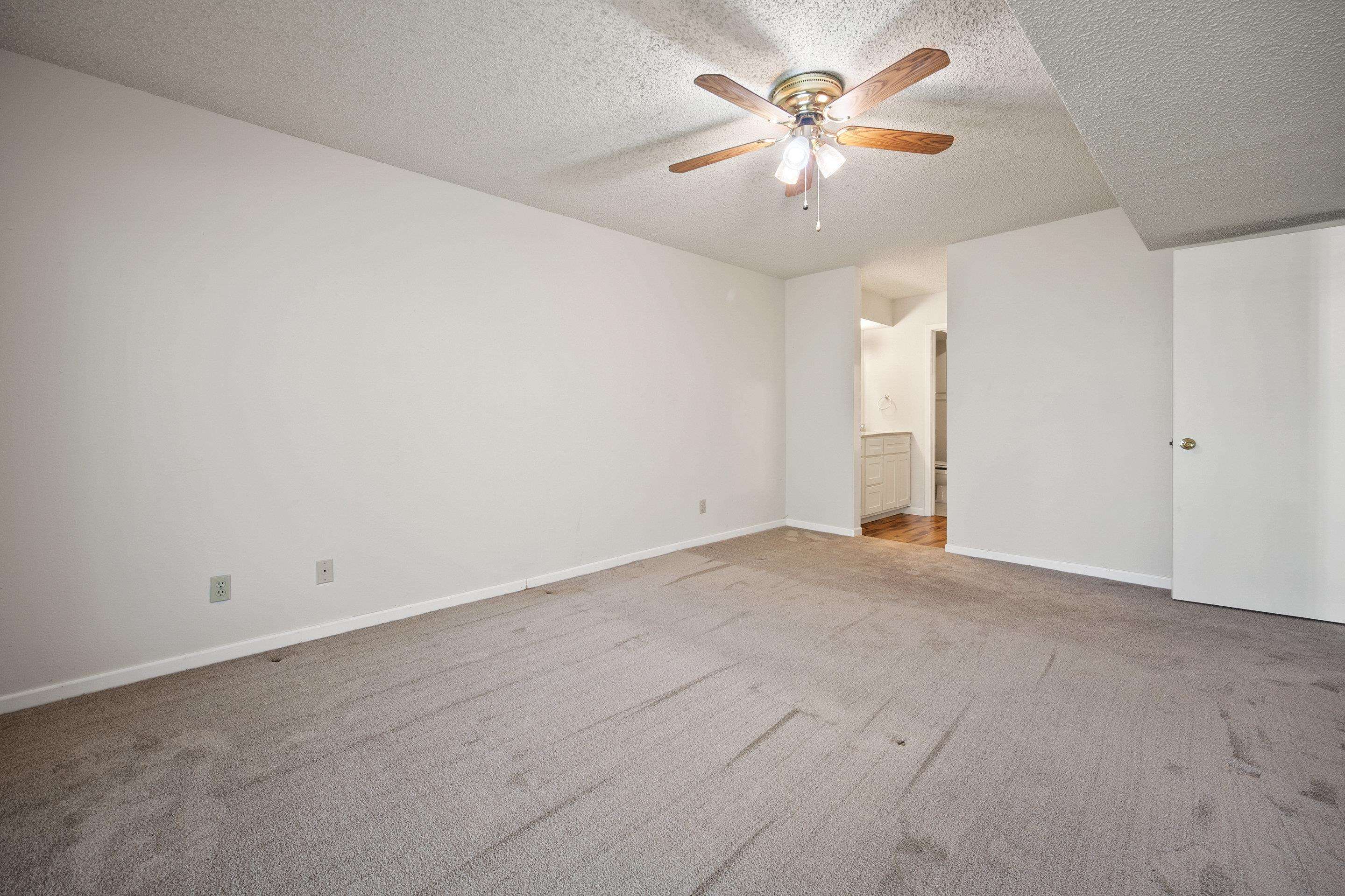 1201 Ranch Road 1431, Unit 2 Marble Falls, TX 78654 - Photo 21 of 26 an empty room with chandelier fan and window