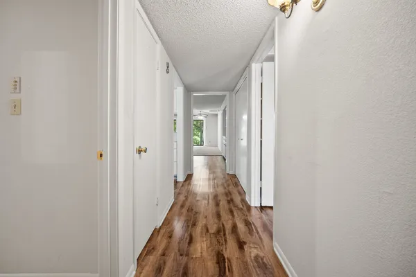 a view of a hallway with wooden floor and staircase