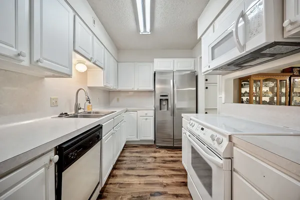 a kitchen with stainless steel appliances a stove sink and cabinets