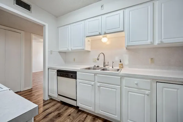 a kitchen with white cabinets and white appliances