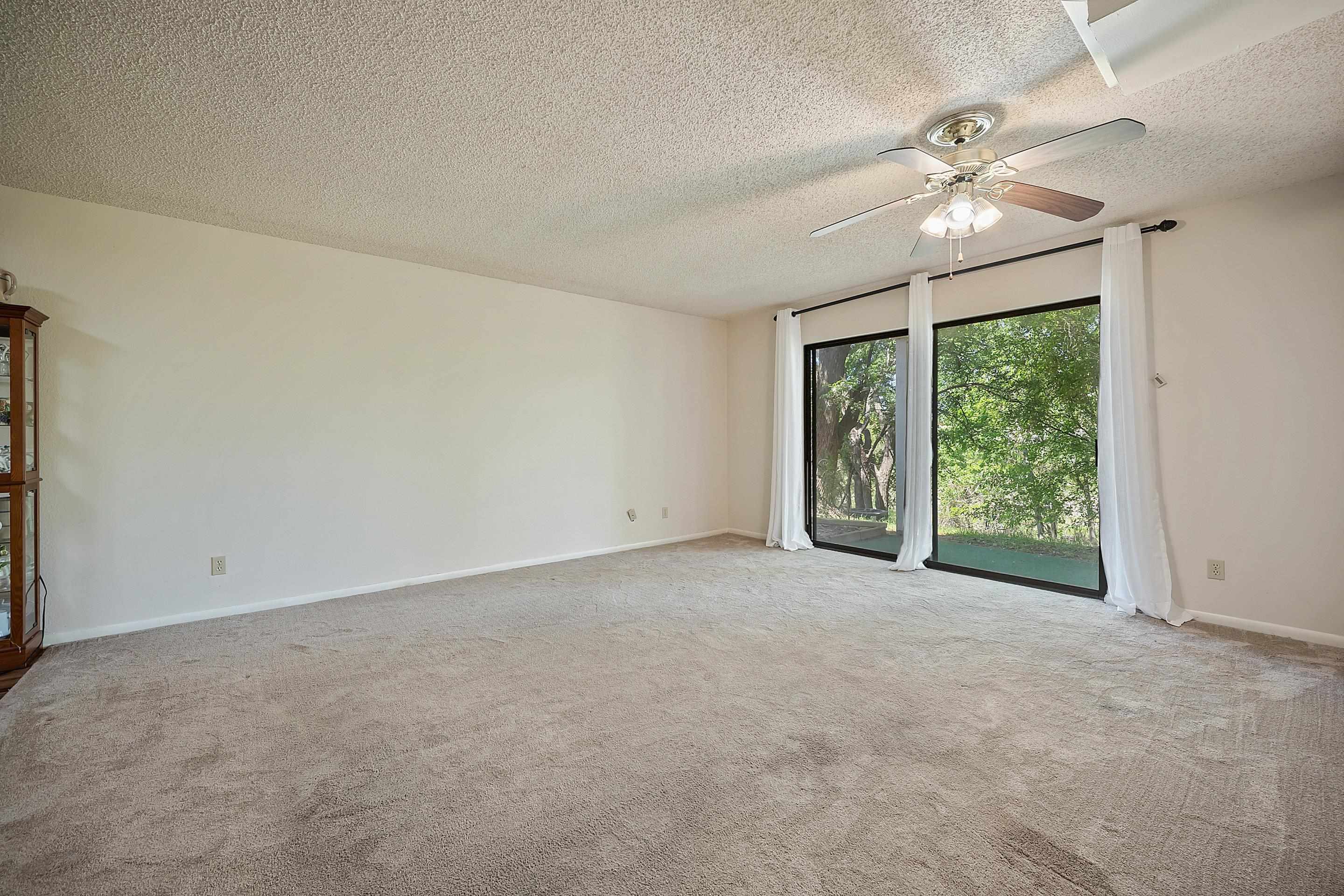 1201 Ranch Road 1431, Unit 2 Marble Falls, TX 78654 - Photo 8 of 26 an empty room with chandelier fan and windows