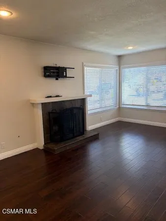 an empty room with windows and fireplace