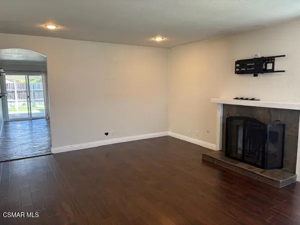 an empty room with wooden floor and a fireplace