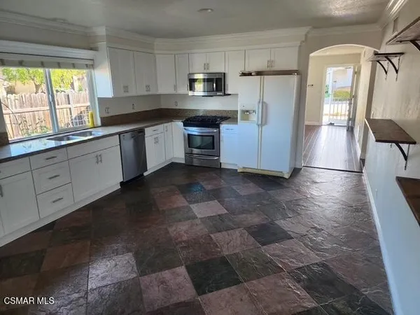 a kitchen with stainless steel appliances granite countertop a refrigerator and a stove
