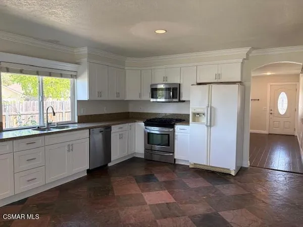 a kitchen with granite countertop white cabinets and stainless steel appliances