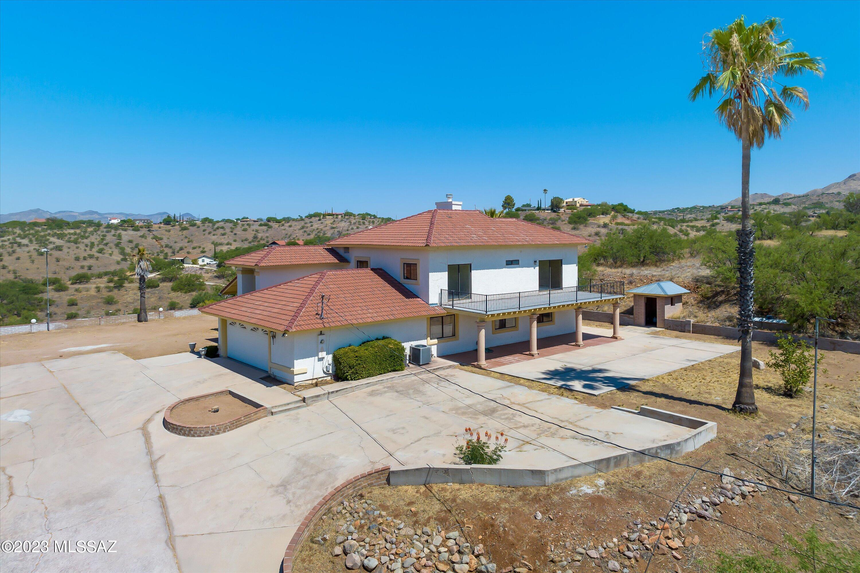 1226 Avenida Gloriosa Rio Rico, AZ 85648 - Photo 39 of 46 a view of a white house with a swimming pool and a yard