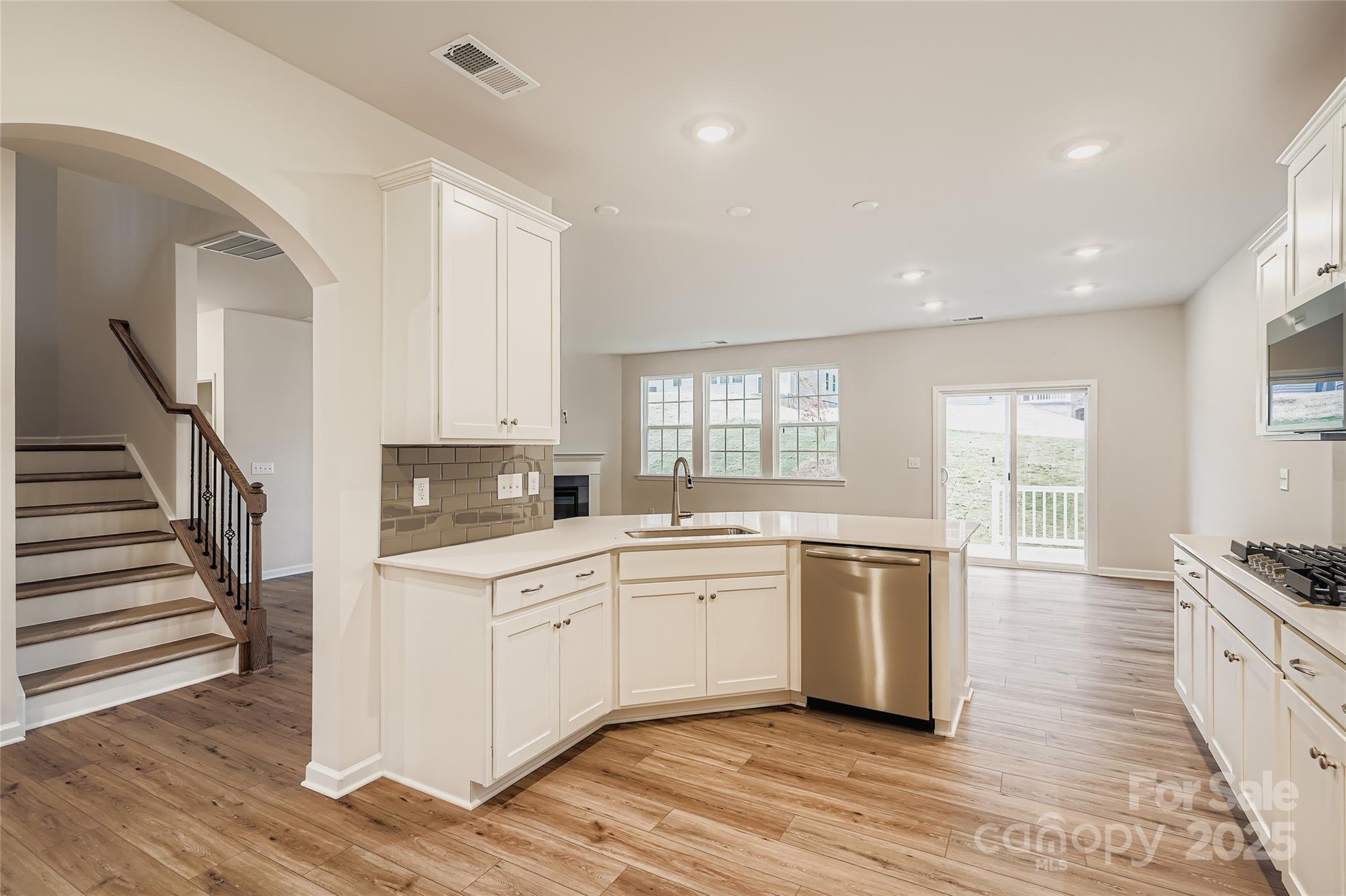 4356 Shimmering Stone Way Maiden, NC 28650 - Photo 5 of 13 a kitchen with a sink cabinets wooden floor and stainless steel appliances