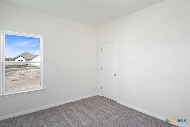an empty room with closet and ceiling fan