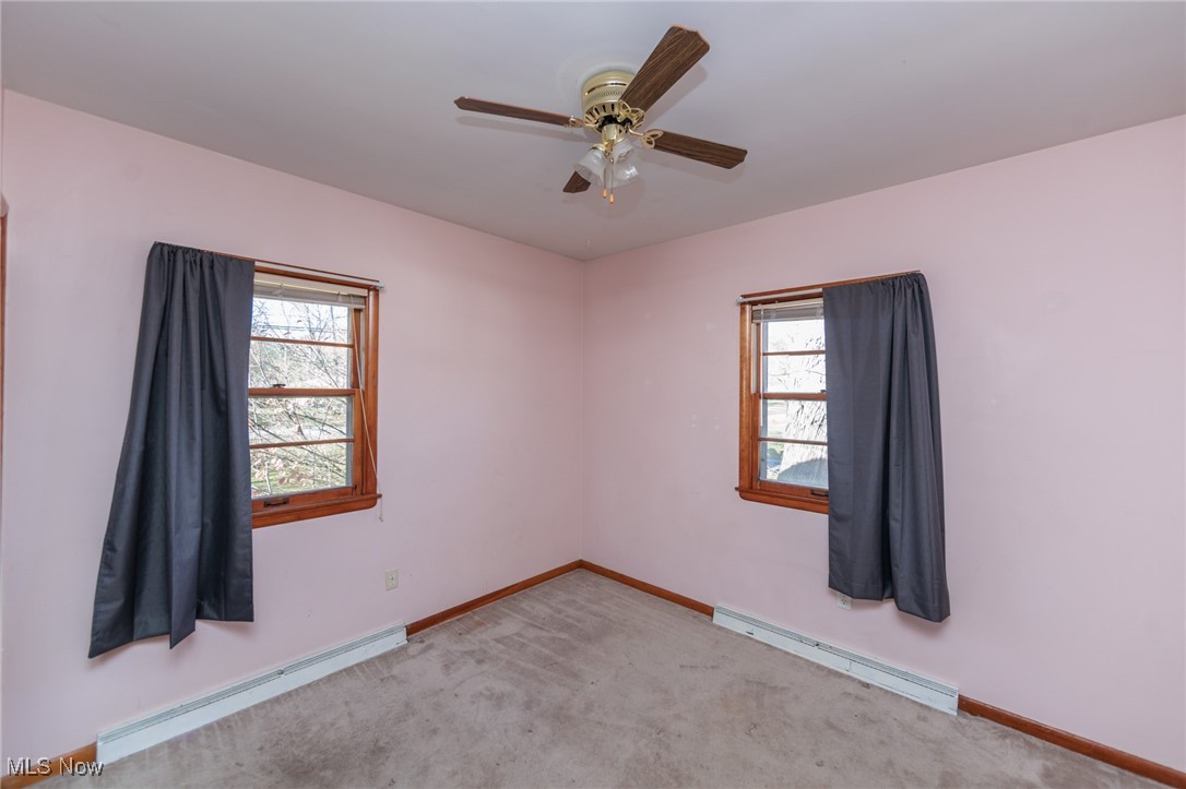 3801 Baird Road Stow, OH 44224 - Photo 16 of 31 Empty room featuring baseboard heating, carpet, and ceiling fan