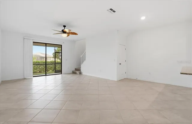 an empty room with a window and a fan