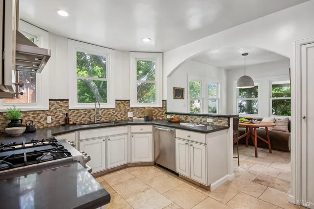 a kitchen with stainless steel appliances a sink stove and cabinets