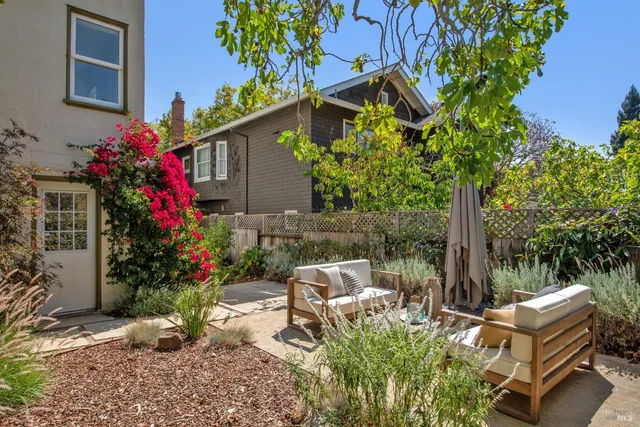a view of backyard with a table and chairs and potted plants