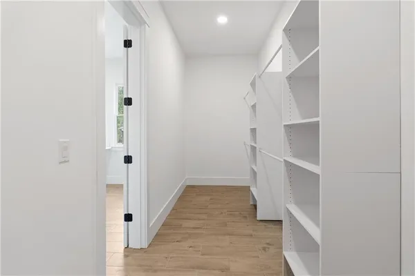a view of walk in closet with empty racks
