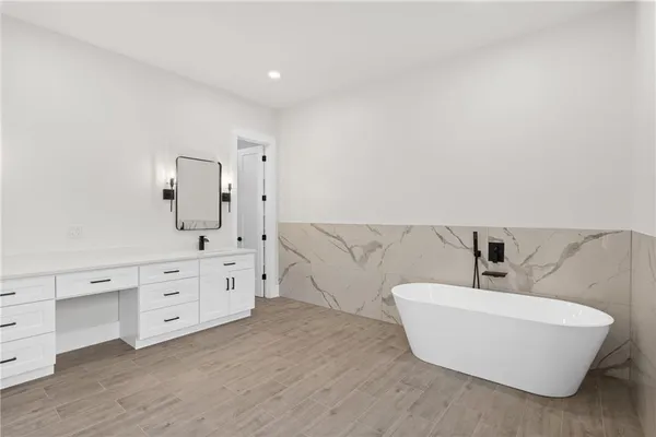 a large white bathroom with a double vanity sink a large mirror and shower