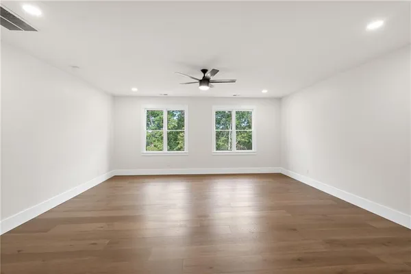 an empty room with closet and a ceiling fan