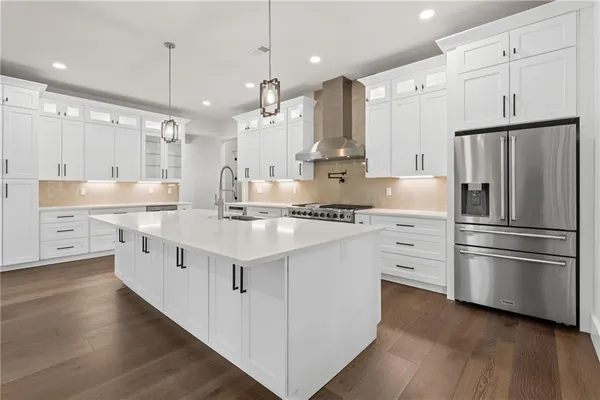 a kitchen with stainless steel appliances a sink stove refrigerator and cabinets