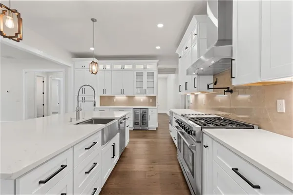 a kitchen with stainless steel appliances a sink stove and cabinets