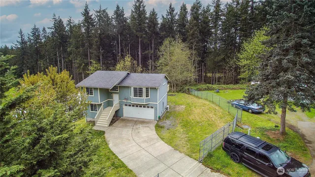 an aerial view of a house with swimming pool garden and trees