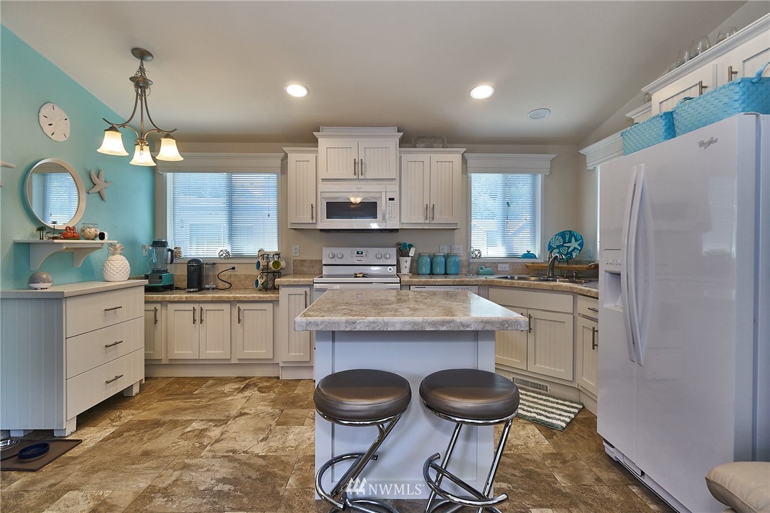 15256 Pine Drive Renton, WA 98058 - Photo 5 of 15 a kitchen with stainless steel appliances granite countertop a sink a stove a refrigerator and cabinets