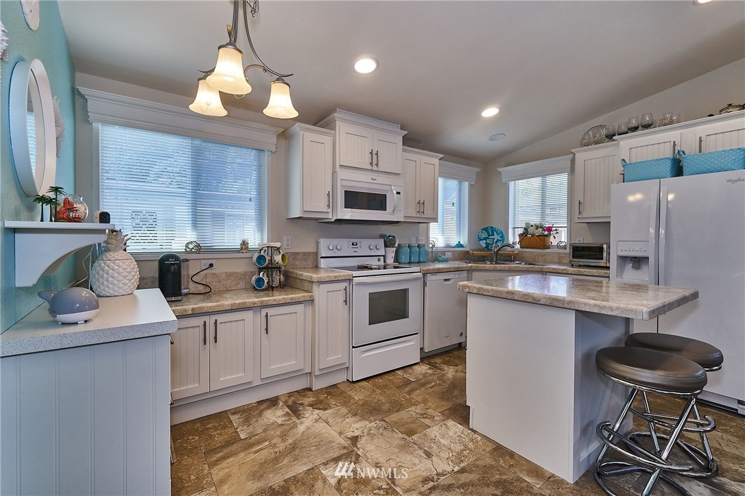 15256 Pine Drive Renton, WA 98058 - Photo 6 of 15 a kitchen with stainless steel appliances granite countertop a sink a stove a refrigerator cabinets and chairs