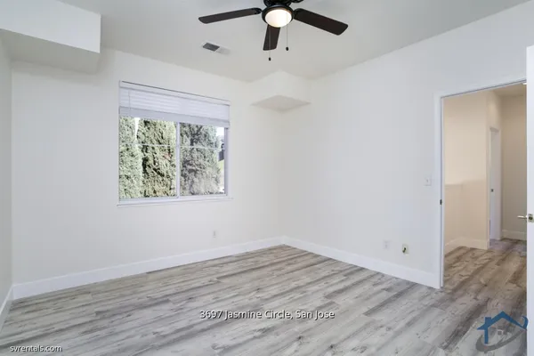 a view of an empty room with wooden floor