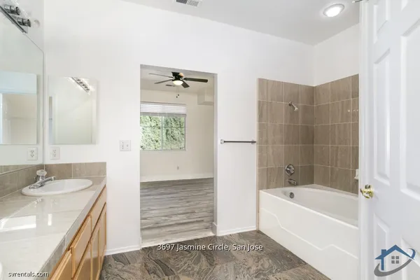 a bathroom with a tub sink and mirror