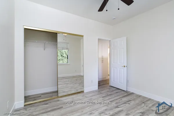 an empty room with closet and mirror