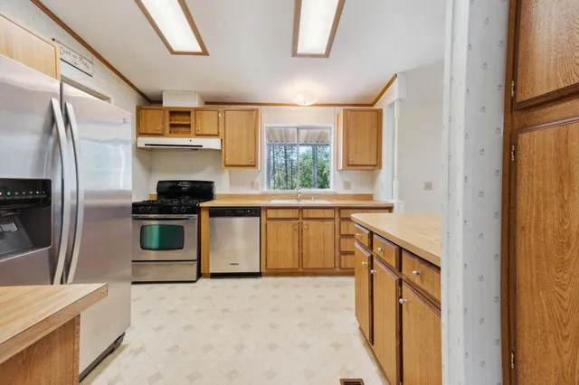 a kitchen with stainless steel appliances granite countertop a sink and a stove