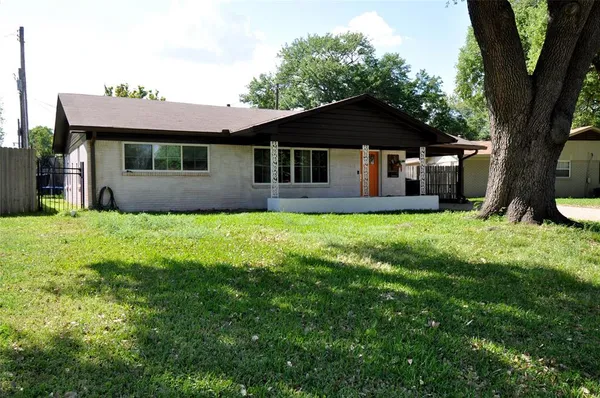 a front view of a house with yard and tree