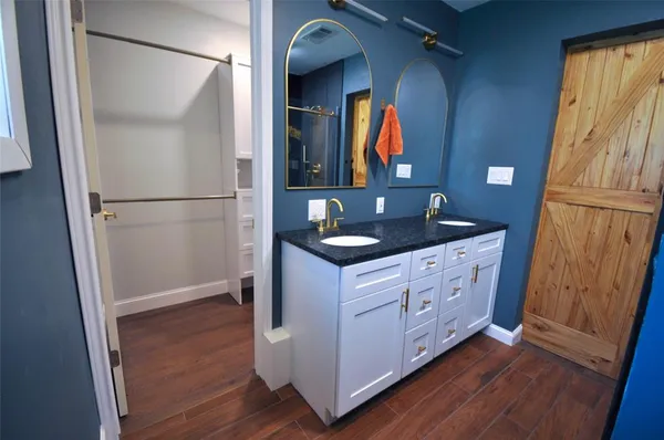 a bathroom with a granite countertop sink and a mirror